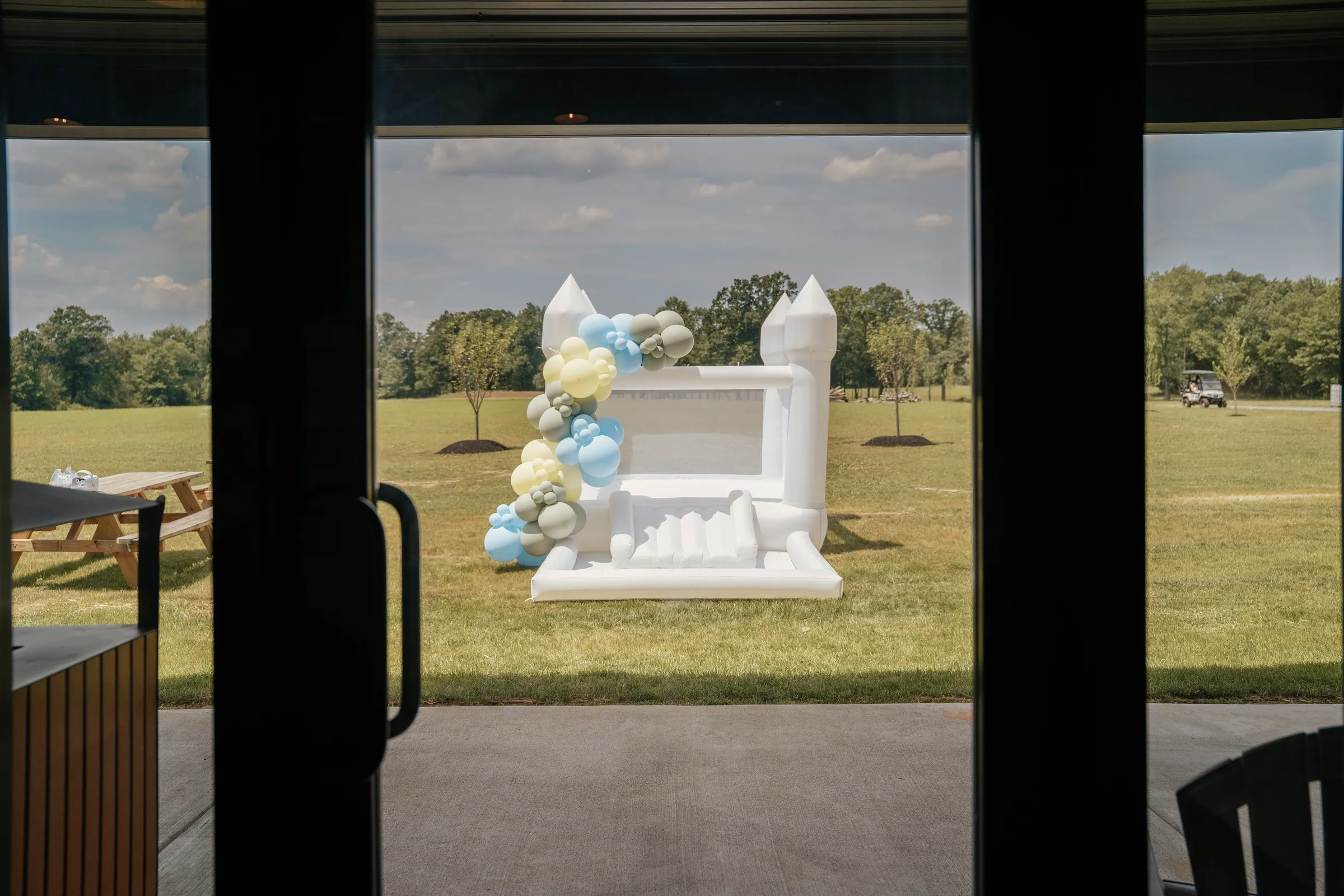 Baldwins Creek Farm - Hopewell Township, NJ: white bounce house with a pastel balloon garland on the lawn for a private party