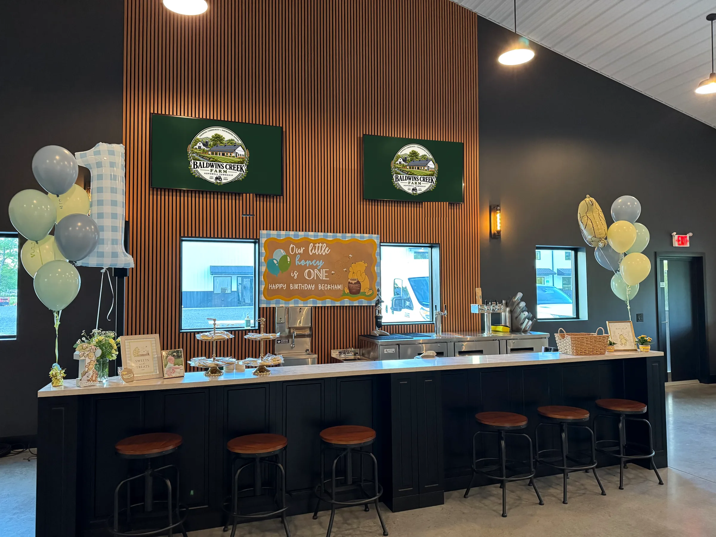Baldwins Creek Farm - Hopewell Township, NJ: private event space bar with stools and the farm logo on the screens